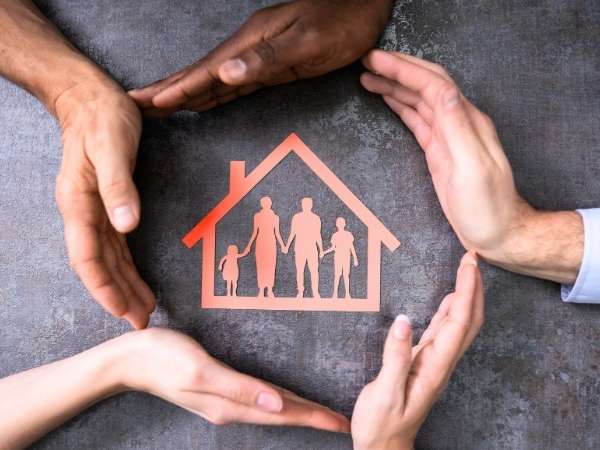Hands surrounding an image of a home.